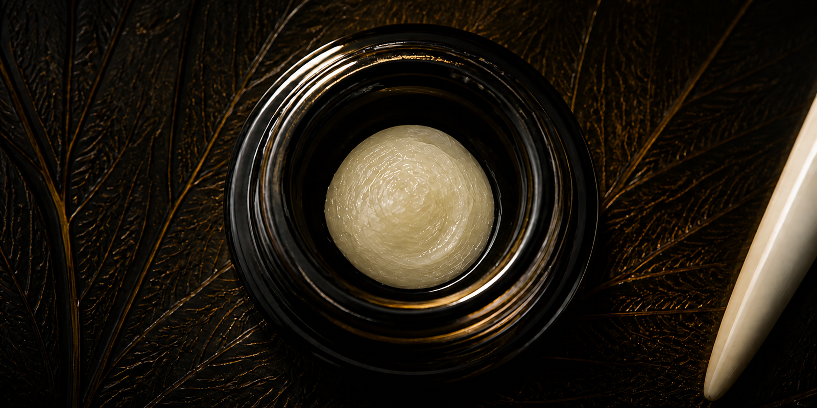 Finished pale live rosin in an open black glass jar